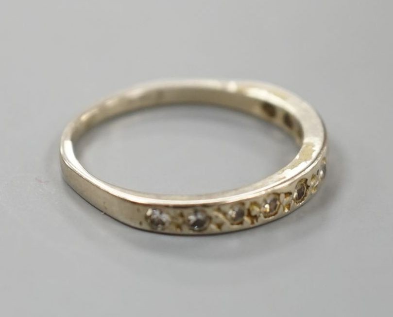 A white metal and diamond chip set half eternity ring, size K